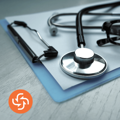 Stethoscope placed on top of a medical file and clipboard on a doctor’s desk.