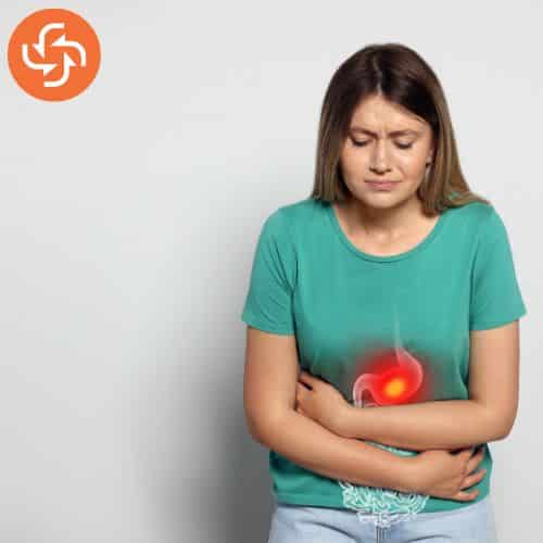 Young woman holding her stomach with a painful expression, highlighting indigestion or stomach pain with a red glowing graphic.